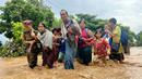 Warga berjalan melintasi banjir di Pyinmana di wilayah Naypyidaw, Myanmar, pada tanggal 13 September 2024. (Sai Aung MAIN/AFP)