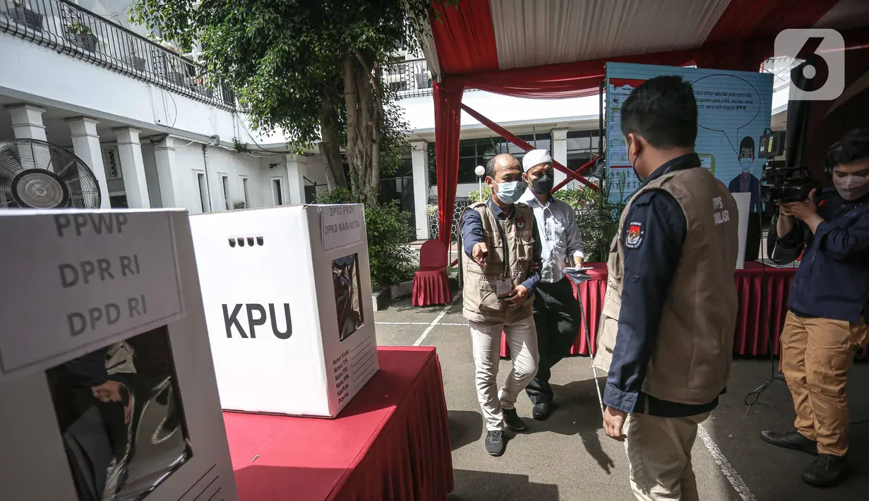Penyandang disabilitas dibantu petuga saat mengikuti simulasi Pemilu 2024 di Kantor KPU RI, Jakarta, Selasa (22/3/2022). Simulasi  digelar untuk memberikan edukasi kepada masyarakat terkait proses pemungutan dan penghitungan suara pemilu serentak tahun 2024. (Liputan6.com/Faizal Fanani)