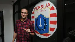 Martin Vunk berpose di depan logo klub Persija Jakarta usai penandatanganan kontrak di Jakarta, (9/12/2014). (Liputan6.com/Helmi Fithriansyah)