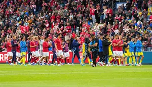 Pemain Timnas Denmark dan Timnas Ukraina berjalan di lapangan usai laga dihentikan karena Christian Eriksen kolaps, Minggu (07/06/2026) malam WIB. (Bo Amstrup/Ritzau Scanpix via AP)