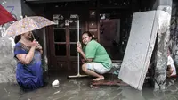 Warga berada di depan rumah saat banjir merendam permukiman Bukit Duri, Jakarta, Kamis (18/2/2021). Hujan deras yang mengguyur sejak pagi menyebabkan permukiman warga di 5 RW, yakni RW 03, 04, 05, 06, dan 07 Kelurahan Bukit Duri terendam banjir. (merdeka.com/Iqbal S Nugroho)