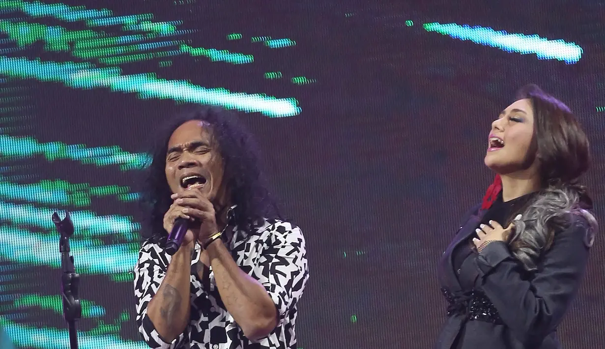 Setelah itu, Slank melajutkan penampilannya dengan membawakan lagu yang berjudul ‘Maafkan’ dan ‘Virus’. Di tengah penampilan, Slank mengajak salah satu slankers wanita bernama Fero untuk duet. (Bambang E. Ros/Bintang.com)