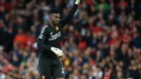 Kiper Manchester United Andre Onana melambai kepada para penggemar selama pertandingan Liga Inggris melawan Wolverhampton Wanderers di Old Trafford, Selasa (15/8/2023). MU menang 1-0 lewat gol Raphael Varane. (Lindsey Parnaby / AFP)