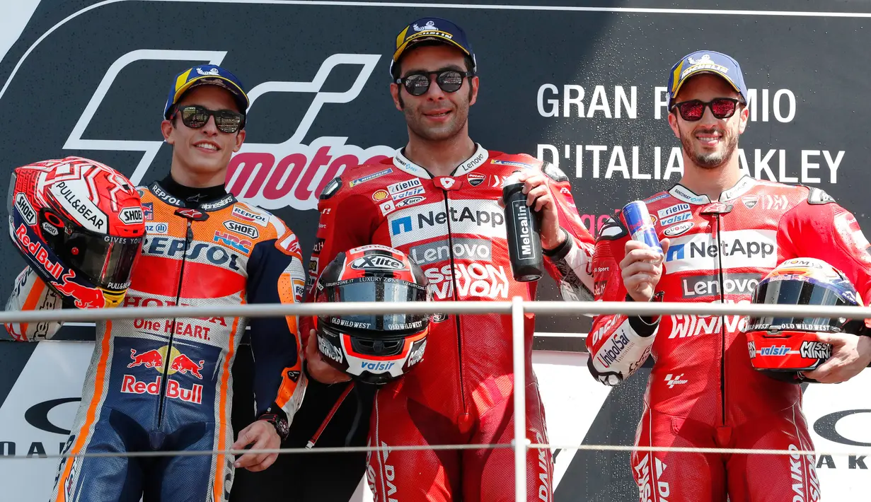 Pembalap Ducati asal Italia, Danilo Petrucci bersama Marc Marquez dan Andrea Dovizioso berada di atas podium usai memenangkan Grand Prix MotoGP Italia di sirkuit Mugello di Scarperia, Italia (2/6/2019). (AP Photo/Antonio Calanni)