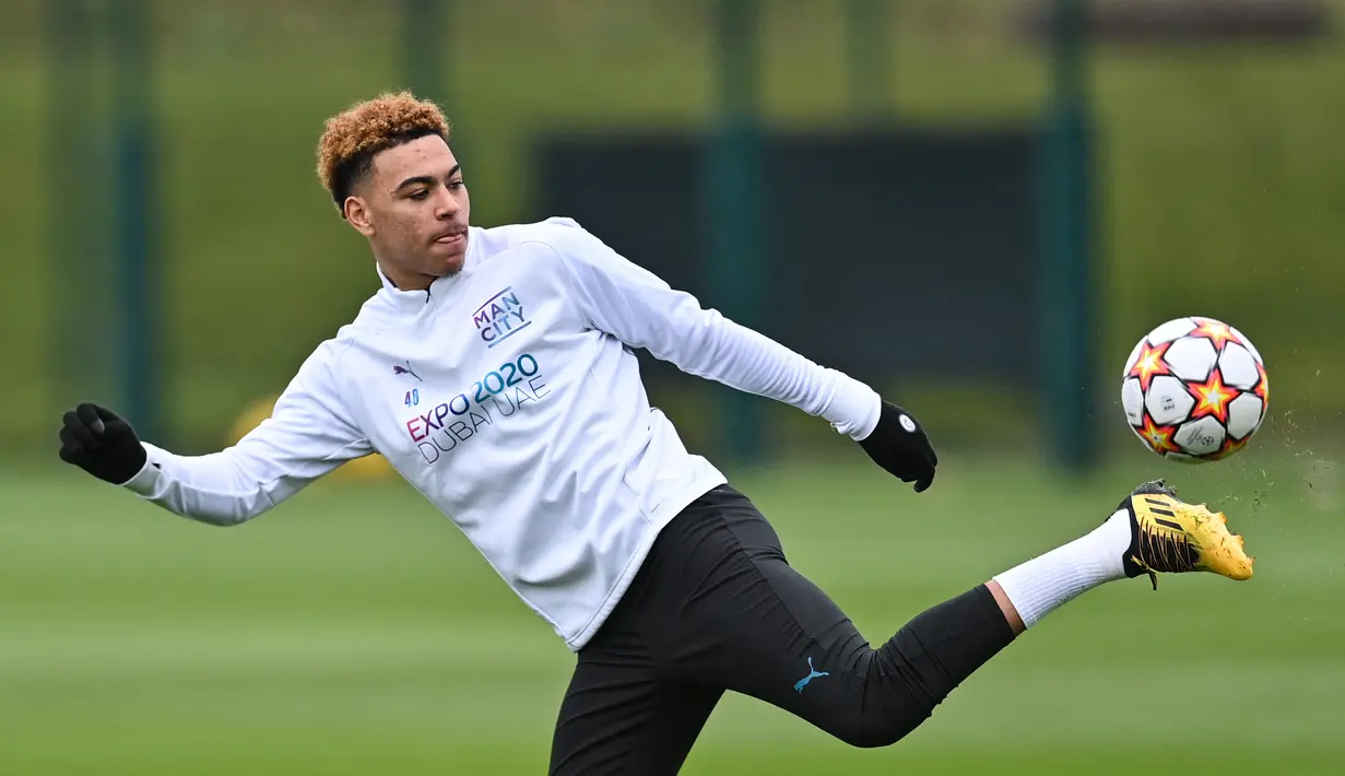 Penyerang Manchester City, Samuel Edozie mengontrol bola saat mengikuti sesi latihan di tempat latihan Manchester City di Manchester, barat laut Inggris (4/4/2022). Man City akan bertanding melawan Atletico Madrid pada leg pertama perempat final Liga Champions di Etihad Stadium. (AFP/Paul Ellis)