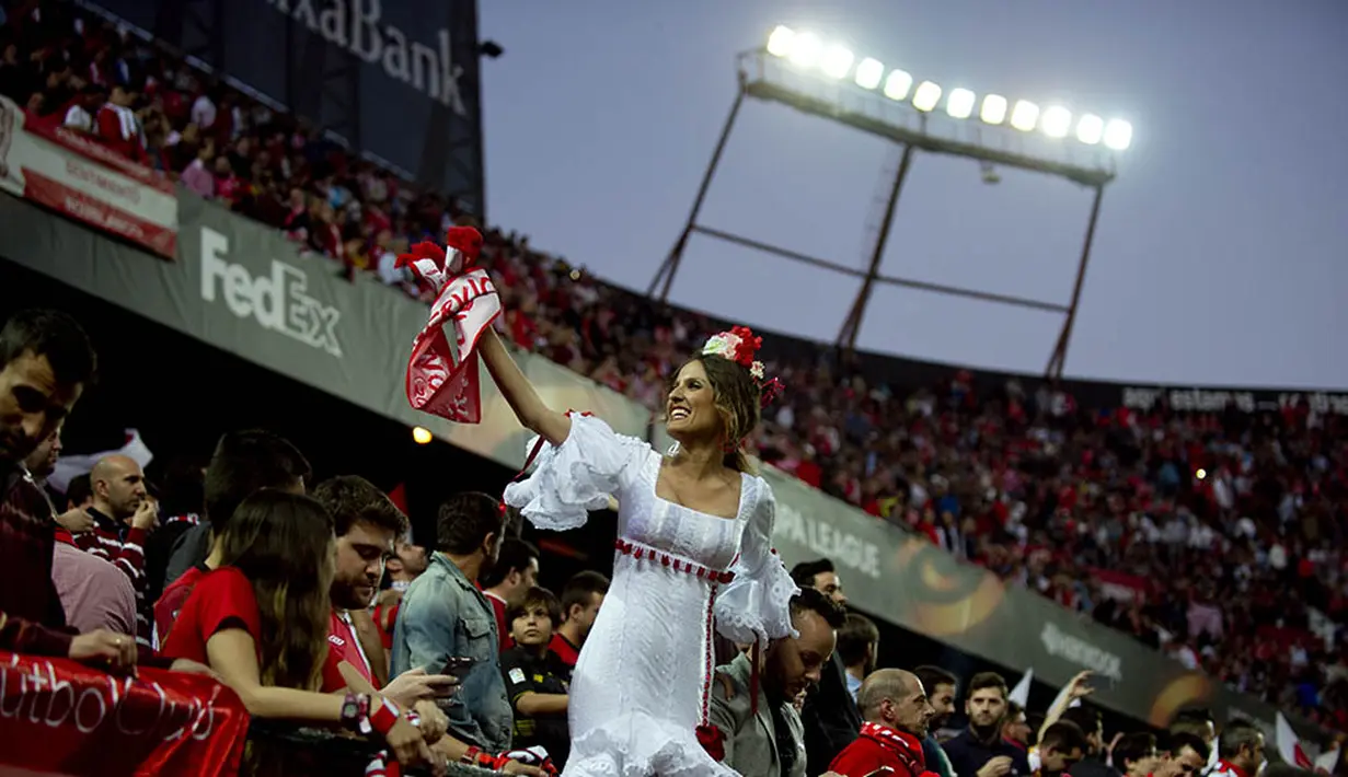 10. Suporter Sevilla menggunakan pakaian flamenca merayakan kemenangan atas Athletic Bilbao pada laga Liga Europa di Stadion Ramon Sanchez Pizjuan, Spanyol, Kamis (14/4/2016). Sevilla lolos ke semifinal berkat menang adu penalti. (AFP/Jorge Guerrero)