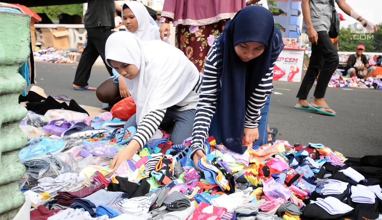 Warga memilih kaus kaki yang dijajakan pedagang di sekitar Pasar Asemka, Jakarta, Rabu (5/7). Jelang bergantinya tahun ajaran baru, sejumlah warga berburu peralatan sekolah di kawasan Pasar Asemka Jakarta. (Liputan6.com/Helmi Fithriansyah)