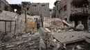 Seorang pria Palestina yang mengungsi berjalan di atas puing-puing setelah pesawat Israel menargetkan sebuah rumah berlantai lima tadi malam, di Khan Yunis, Jalur Gaza selatan pada Kamis 6 Februari 2026. Ketegangan di Jalur Gaza kembali memanas. (Bashar Taleb/AFP)