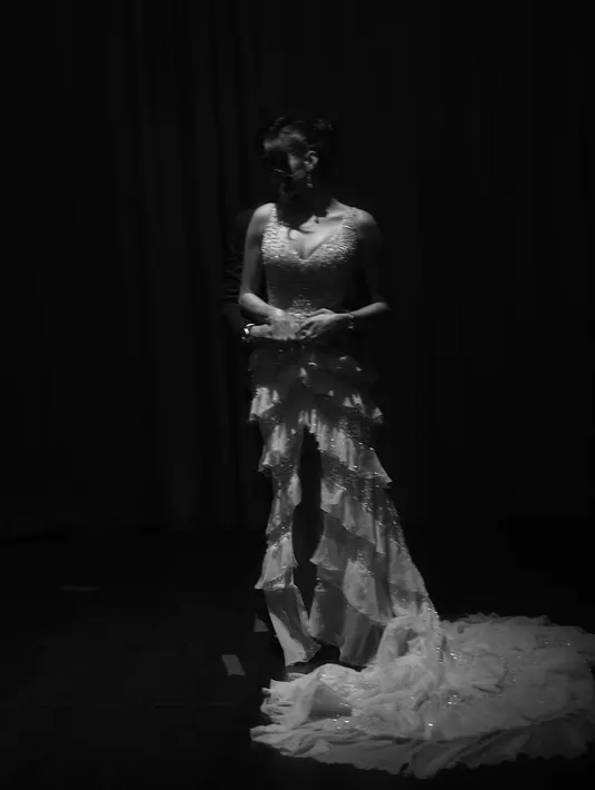 Gaunnya menampilkan desain yang menggoda. Garis leher v-neck dengan anggun membingkai décolletage-nya, celah tinggi yang berani membangkitkan sensualitas yang halus. [@mryoiepratama].