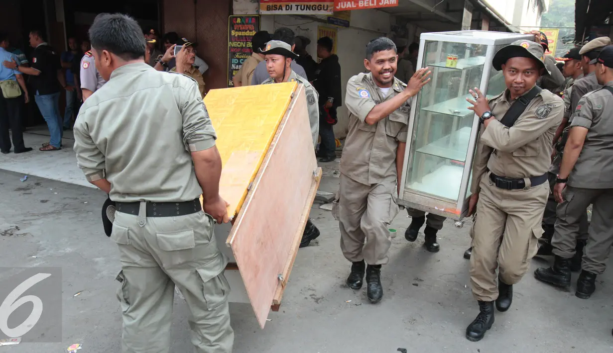 Petugas Satpol PP mengeluarkan barang-barang yang berada di kios Kavling 36 Pasar Benhil, Jakarta, (29/8/2015). Pembongkaran dilakukan berdasarkan putusan PTUN Jakarta yang memenangkan PD Pasar Jaya. (Liputan6.com/Gempur M Surya)