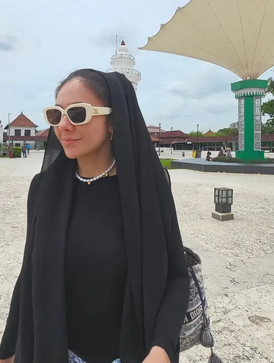 Wulan memilih mengenakan atasan hitam lengan panjang. Ia pun menyematkan kerudung hitam yang hanya disematkan di kepalanya tanpa menutupi lehernya. Rambut yang diikat tampak terlihat. [@wulanguritno]