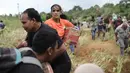 Pemerintah memastikan distribusi bantuan menjangkau seluruh wilayah, termasuk wilayah yang masih terisolir. Tampak dalam foto, para penyintas banjir membawa barang-barang bantuan yang didistribusikan oleh helikopter TNI AU di Aceh Tengah, Sabtu 6 Desember 2025. (AP Photo/Reza Saifullah)