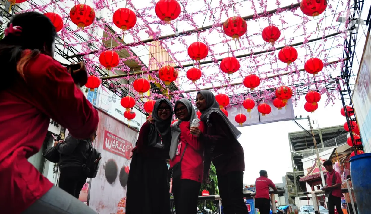 Sejumlah remaja foto bersama di Pasar Imlek Semawis 2570, kawasan Pecinan Semarang, Jawa Tengah, Sabtu (2/1). Berbagai pernak-pernik berbau Imlek ada di pasar ini. (Liputan6.com/Gholib)