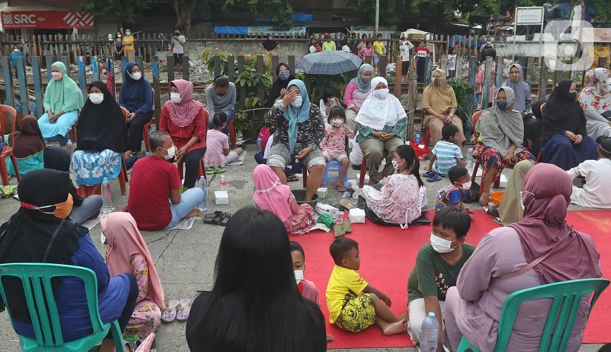 Sejumlah anak mencuci kaki ibu mereka di Kelurahan Duri Pulo, Jakarta, Rabu (21/12/2021). Aksi mencuci kaki ibu secara massal yang diikuti 500 peserta itu bertujuan untuk meningkatkan rasa cinta kasih kepada ibu dan dilakukan dalam rangka memeriahkan Hari Ibu. (Liputan6.com/Herman Zakharia)