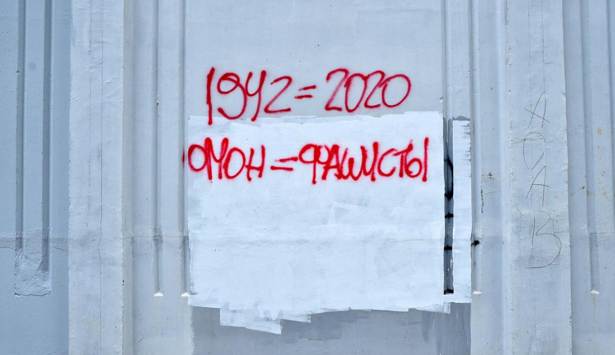 Sebuah prasasti bertuliskan "1942 = 2020 Polisi anti huru hara = fasis" terlihat dicat dengan cat semprot di dinding di Minsk (25/8/2020). Alexander Lukashenko mengklaim dirinya menang pada masa jabatan keenam dalam pemilihan yang disengketakan pada 9 Agustus. (AFP/Sergei Gapon)