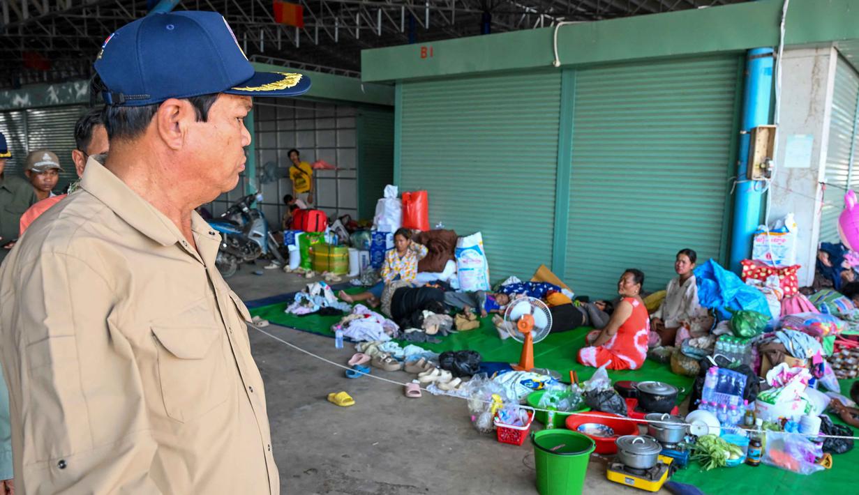 Laporan berbagai media internasional menyebutkan, lebih dari 600 ribu warga sipil terpaksa meninggalkan rumah mereka. Tampak dalam foto, Kun Kim (kiri), menteri senior Kamboja untuk misi khusus dan wakil presiden pertama Komite Nasional untuk Manajemen Bencana (NCDM), memeriksa kamp sementara untuk pengungsi di provinsi Banteay Meanchey pada Sabtu 13 Desember 2025, di tengah bentrokan di sepanjang perbatasan Kamboja-Thailand. (TANG CHHIN SOTHY/AFP)