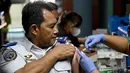 Seorang petugas bandara mendapatkan vaksinasi COVID-19 keempat atau booster kedua di kantor otoritas Bandara Ngurah Rai, dekat Denpasar, Bali, Senin (30/1/2023). Pemerintah Provinsi (Pemprov) Bali melakukan program vaksinasi booster kedua usai dibukanya penerbangan langsung (direct flight) dari China pada Minggu (22/1) lalu. (SONNY TUMBELAKA / AFP)