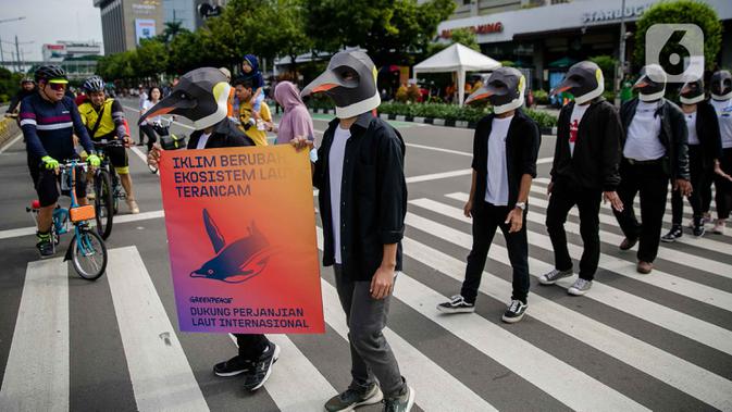 Sejumlah aktivis Greenpeace mengenakan topeng penguin saat menggelar aksi dalam car free day di kawasan Thamrin, Jakarta, Minggu (9/2/2020). Mereka mengajak pemerintah untuk berpartisipasi dalam mewujudkan Perjanjian Laut Internasional (Global Ocean Treaty). (Liputan6.com/Faizal Fanani)