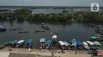 Sejumlah nelayan bersiap untuk melarung replika kapal berisi sesaji di Pantai Tarumajaya, Kabupaten Bekasi, Jawa Barat, Jumat (28/1/2022). Ritual ini diikuti sebanyak 40 kapal nelayan dari enam Muara. (Liputan6.com/Herman Zakharia)