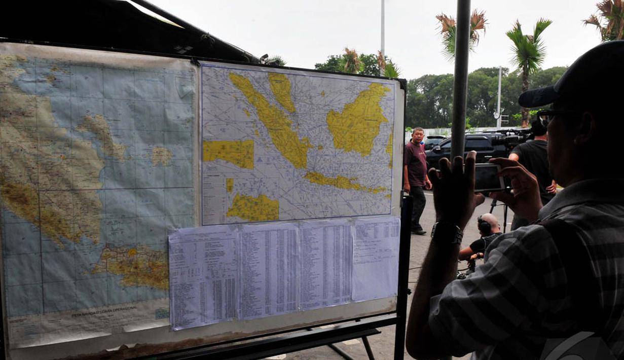Seorang pria tampak mengambil gambar peta lokasi pencarian pesawat AirAsia QZ8501, Surabaya, Jatim, Selasa (30/12/2014). (Liputan6.com/Johan Tallo)