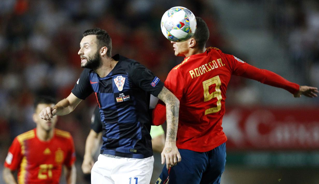 Striker Spanyol, Rodrigo Moreno, duel udara dengan gelandang Kroasia, Marcelo Brozovic, pada laga UEFA Nations League di Stadion Manuel Martinez Valero, Selasa (11/9/2018). Spanyol menang 6-0 atas Kroasia. (AP/Alberto Saiz)