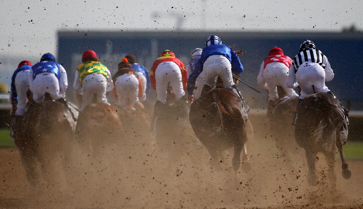 Para joki berlomba dalam lomba pacuan kuda Dubai Kahalya Classic yang menjadi bagian dalam Dubai World Cup di lintasan pacuan kuda Meydan, UEA, (26/3/2016). (AFP/Marwan Naamani)