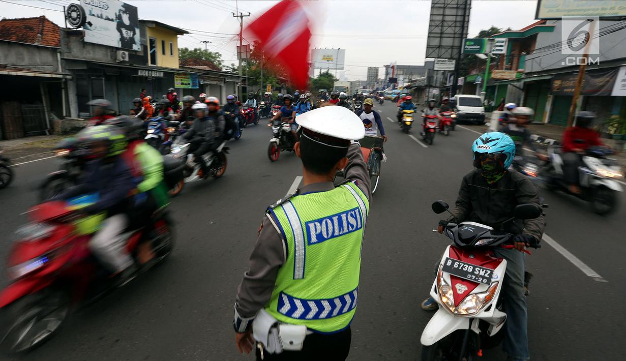 Personel polisi mengatur arus lalu lintas di jalur pantai utara (pantura) Cirebon, Jawa Barat, Kamis (22/6). Tiga hari menjelang lebaran, pemudik pengguna sepeda motor yang melintas di jalur Cirebon meningkat signifikan. (Liputan6.com/Johan Tallo)
