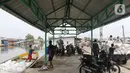 Pekerja mengangkut barang menggunakan perahu menuju dermaga di Desa Pantai Mekar, Muaragembong, Kabupaten Bekasi, Senin (6/12/2021). Jasa angkut barang menggunakan perahu tersebut banyak diminati warga untuk mempersingkat waktu perjalanan. (Liputan6.com/Herman Zakharia)