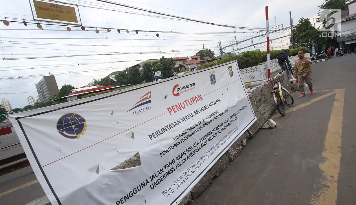 Spanduk sosialisasi penutupan perlintasan kereta api di Jalan Angkasa Raya Kemayoran, Jakarta, Kamis (26/10). Penutupan perlintasan kereta api tersebut mendapat protes warga karena membuat Jalan Angkasa semakin macet. (Liputan6.com/Immanuel Antonius)