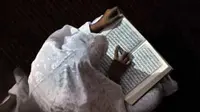 Seorang ibu membaca Al Quran sebelum ibadah shalat Tarawih yang pertama di Masjid Istiqlal, Jakarta. (Antara)