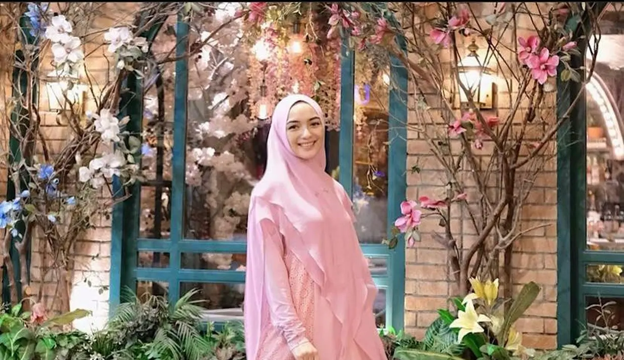 Citra Kirana tampil sederhana mengenakan dress dan hijab syar’i warna pink. [Foto: IG/citraciki].