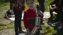 Seorang anak memegang kereta mainan di luar rumah keluarganya yang rusak parah setelah serangan Rusia di Pokrovsk, Ukraina timur, Rabu (25/5/2022). Dua roket menghantam kota Pokrovsk, di wilayah Donetsk pada Rabu pagi, menyebabkan sedikitnya empat cedera. (AP Photo/Francisco Seco)