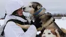 Tentara Brigade Arktik Armada Utara Rusia dicium anjing saat melatihnya di Rusia, Selasa (26/11/2019). Militer Rusia telah mempekerjakan anjing sejak awal tahun 1840, tepatnya selama Perang Kaukasia. (Andrei Luzik, Russian Defense Ministry Press Service via AP)