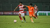 Pemain Madura United, Dodi Alexvan Djin, berusaha mempertahankan penguasaan bola dari sergapan pemain Borneo FC pada leg 1 semifinal Championship Series BRI Liga 1 2023/2024 di Gelora Bangkalan, Madura, Rabu (15/5/2024). (Bola.com/Wahyu Pratama)