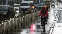 Warga menaiki sepeda saat hujan di kawasan Bundaran Hotel Indonesia, Jakarta, Senin (1/11/2021). BMKG mengeluarkan peringatan dini cuaca ekstrem berupa hujan dengan intensitas sedang hingga lebat untuk berbagai wilayah di Indonesia hingga 6 November 2021. (Liputan6.com/Faizal Fanani)