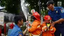 Petugas pemadam kebakaran mengajari anak-anak TK cara memadamkan api di Jakarta, Kamis (21/3). Kegiatan ini bertujuan mengenalkan profesi pemadam kebakaran dan memberi pengetahuan proses pemadaman api kepada anak usia dini. (merdeka.com/Imam Buhori)
