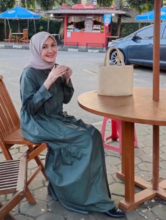 Ngopi cantik, judul yang cocok untuk foto Henidar Amroe yang ini. Walau tak disapu make up, Henidar yang memilih gamis hijau dengan hijab abu-abu ini memang terlihat cantik. (Foto: Instagram/@henidaramroe)