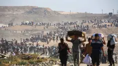 Orang-orang berjalan membawa tas-tas berisi bantuan kemanusiaan yang mereka terima di pusat distribusi yang dikelola oleh Yayasan Kemanusiaan Gaza (GHF) yang didukung Ameriks Serikat dan Israel, di koridor Netzarim, Nuseirat, Jalur Gaza tengah, pada 26 September 2025. (Eyad BABA/AFP)