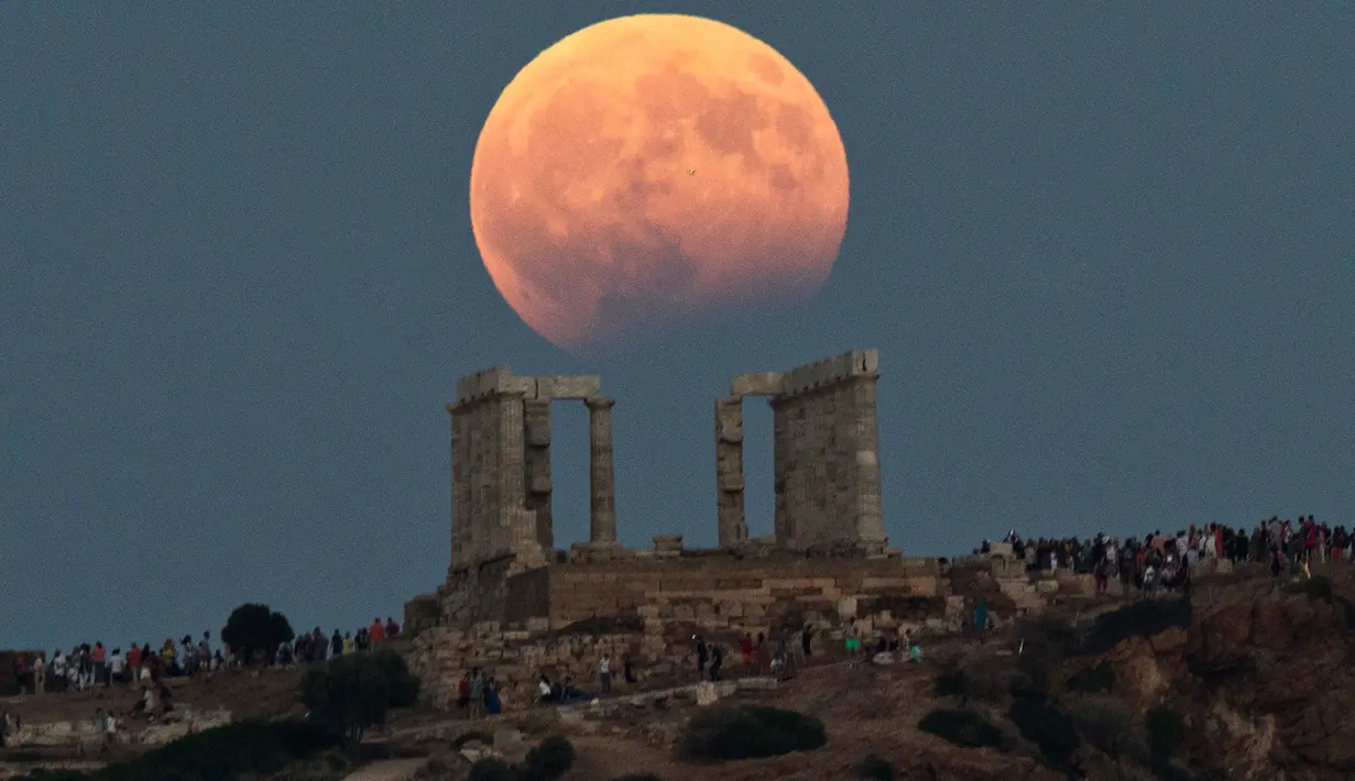 Gerhana bulan parsial terlihat di atas kuil Poseidon di Cape Sounion, Yunani, Senin (7/8). Gerhana bulan parsial terjadi ketika bumi bergerak di antara bulan dan matahari, tapi tidak persis dalam satu garis. (AP Photo/Petros Giannakouris)