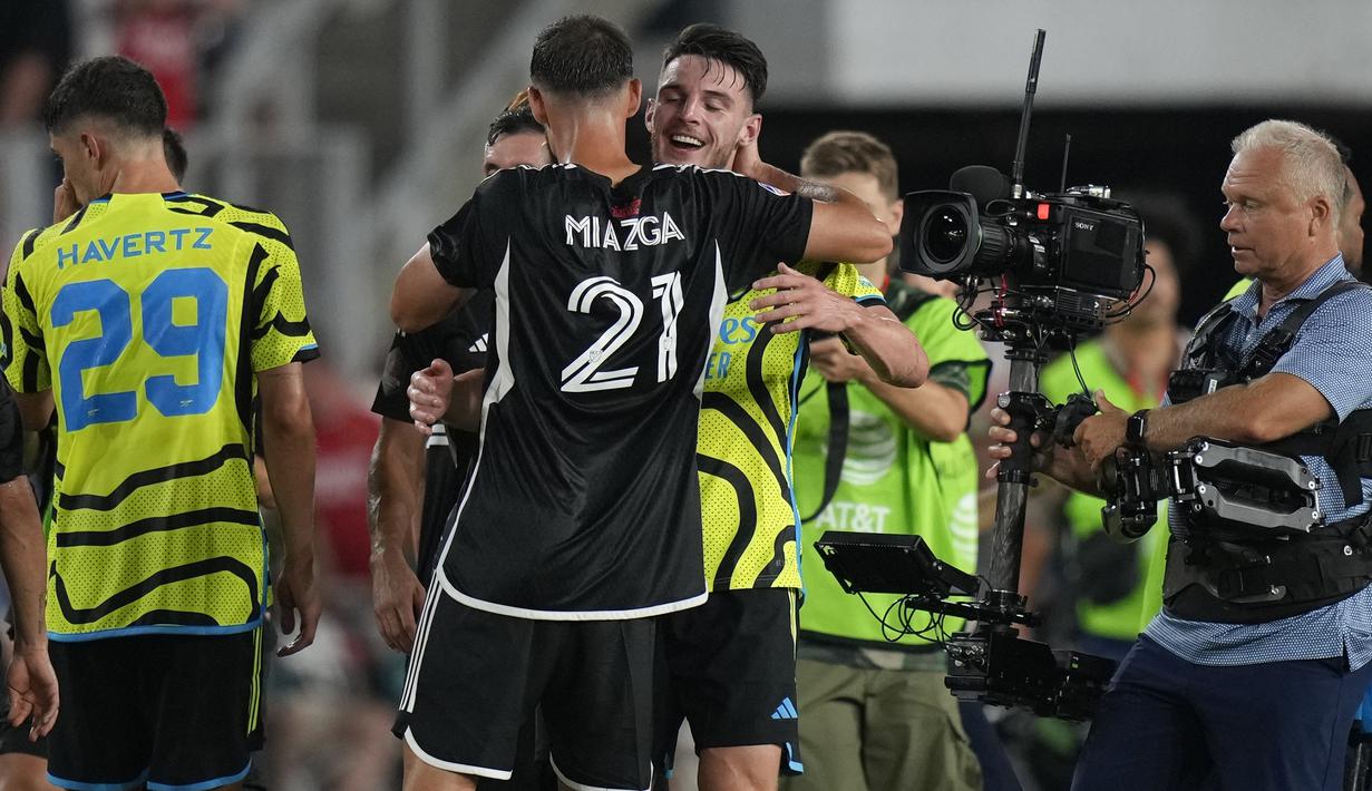 Gelandang Arsenal, Declan Rice (kanan) berpelukan dengan bek MLS All-Stars, Matt Miazga setelah berakhirnya laga pramusim 2023/2024 di Washington DC, Amerika Serikat, Kamis (20/7/2023) pagi WIB. (AP Photo/Alex Brandon)