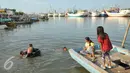 Sejumlah anak berenang di laut di kawasan Luar Batang, Penjaringan, Jakarta, Senin (28/3). Pemprov DKI Jakarta menargetkan pembangunan 300 Ruang Publik Terpadu Ramah Anak (RPTRA) di seluruh kawasan Jakarta. (Liputan6.com/Gempur M Surya) 