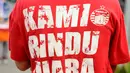 Seorang suporter Persija mengenakan kaus bertluiskan Kami Rindu Juara jelang menyaksikan laga Persija melawan Bali United di Stadion Patriot Candrabhaga, Bekasi, Minggu (21/5). Laga kedua tim berakhir imbang 0-0. (Liputan6.com/Helmi Fithriansyah)
