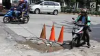 Pengendara menghindari jalan berlubang di kawasan Tanjung Barat, Jakarta, Rabu (30/1). Musim penghujan, pengguna jalan mengeluhkan jalan berlubang yang dipenuhi air.  (Liputan6.com/Immanuel Antonius)
