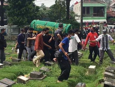 Sejumlah keluarga dan kerabat dari Markis Kido mengantarkan jenazah ke tempat peristirahatan terakhir di TPU Kebon Nanas, Jakarta, Selasa (15/6/2021). (Foto: Bola.com/Erwin Fitriansyah)