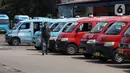 Seorang pria melintasi deretan angkutan kota (angkot) yang terparkir di Terminal Grogol, Jakarta, Sabtu (27/8/2022). Wakil Gubernur DKI Jakarta Ahmad Riza Patria berharap kenaikan tarif ojek online yang dimulai pada 29 Agustus mendatang bisa membuat banyak warga ibu kota beralih ke angkutan umum. (Liputan6.com/Angga Yuniar)