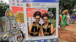 Warga berfoto menggunakan atribut saat launching pemilihan Gubernur dan Wakil Gubernur 2017 di Jakarta, Minggu (18/9). Launching tersebut bertujuan untuk mengedukasi masyarakat Jakarta menjelang Pilkada 2017. (Liputan6.com/Faizal Fanani)