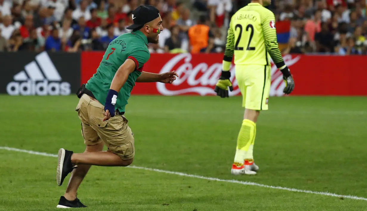 Suporter Portugal berlari memasuki lapangan mengejar Ronaldo saat Portugal melawan Polandia pada perempat final Piala Eropa 2016 di Stade Velodrome, Marseille, (1/7/2016) dini hari WIB. (REUTERS/Kai Pfaffenbach)