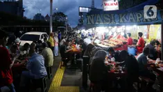 Warga menikmati waktu serta menu berbuka puasa di Sentra Kuliner Nasi Kapau di Jalan Kramat Raya, Senen, Jakarta, Senin (17/3/2025). (Liputan6.com/Herman Zakharia)