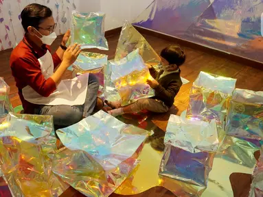 Anak bersama guru bermain di sela-sela pembukaan Studio Ganara Art di PIK Avenue, Jakarta (14/06/2022). Menyambut libur sekolah lembaga pendidikan seni dan budaya yang didirikan Tita Djumaryo membuka Studio Ganara Art yang ketiga. (Liputan6.com/Fery Pradolo)