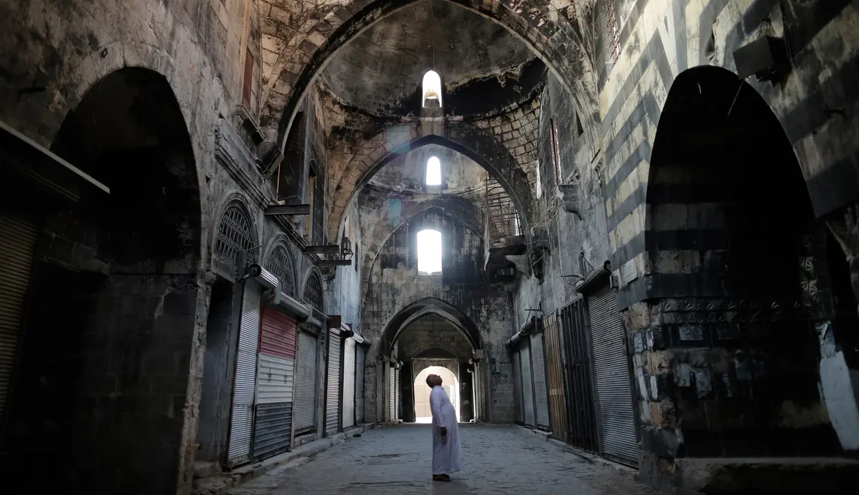 Seorang pria memeriksa sebuah pasar di Kota Tua Aleppo, Suriah, Sabtu (27/7/2019). Kendati sebagian besar pasar masih tutup setelah pertempuran besar tiga tahun lalu, kegiatan ekonomi perlahan mulai tumbuh di kota terbesar di Suriah tersebut. (AP Photo/Hassan Ammar)